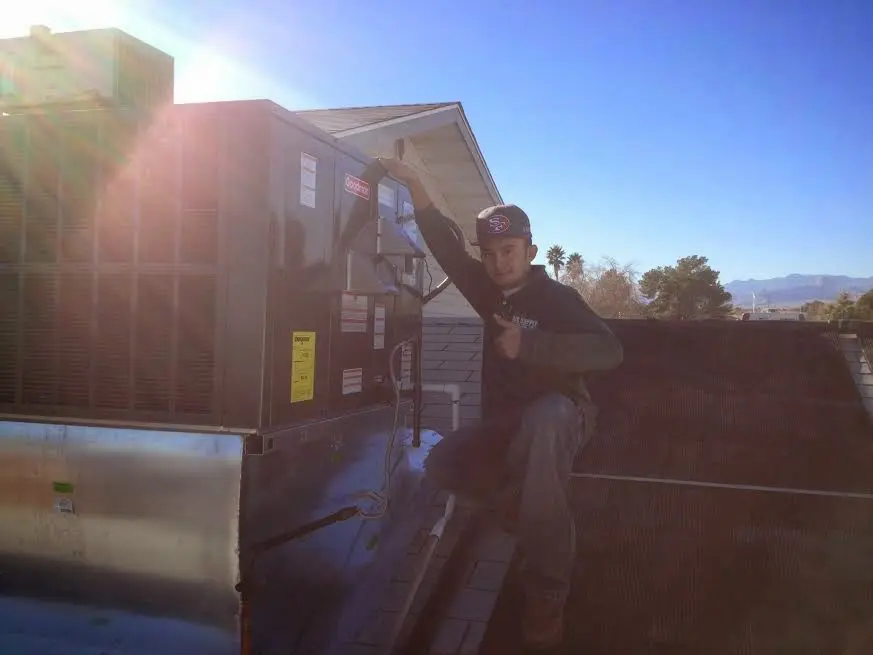 HVAC technician performing HVAC Inspection on a rooftop unit in Larchmont